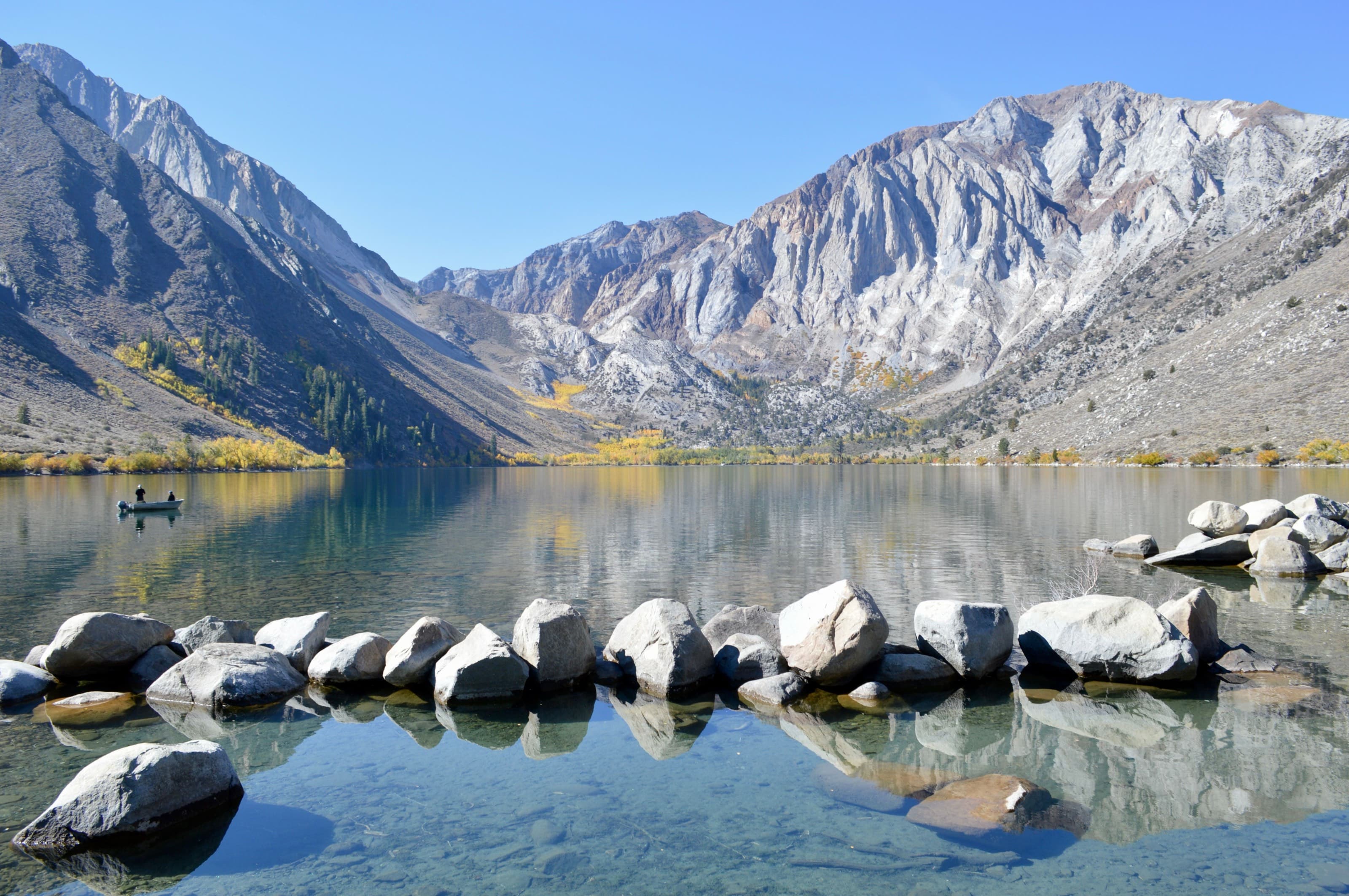 Convict Lake in the Eastern Sierra, granite peaks and autumn aspens reflected in still water just off US-395